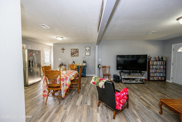 dining room featuring hardwood / wood-style floors and a textured ceiling