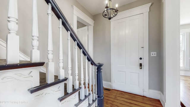 entrance foyer with hardwood / wood-style flooring and an inviting chandelier