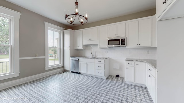 kitchen featuring sink, an inviting chandelier, backsplash, white cabinets, and appliances with stainless steel finishes