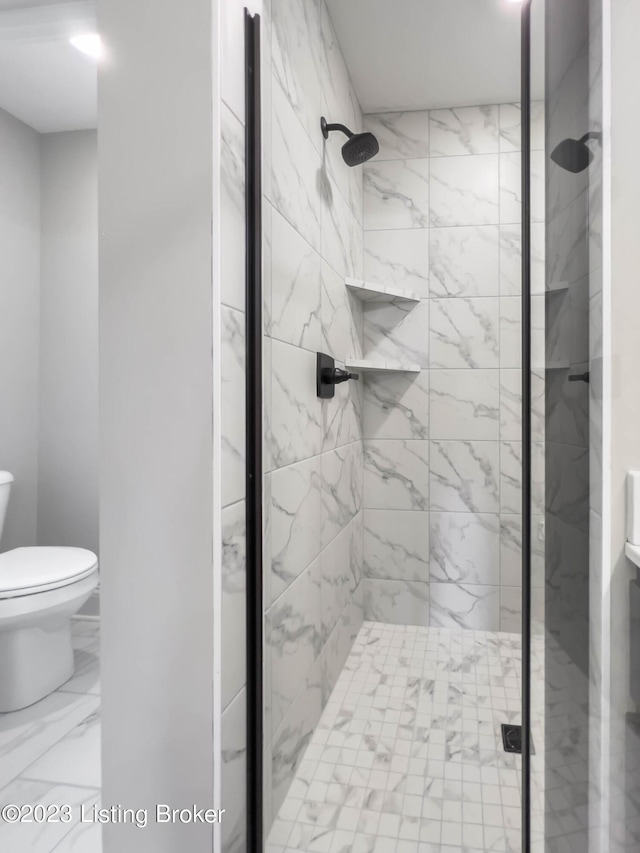 bathroom featuring toilet and a shower with shower door