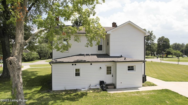 back of property with a lawn and cooling unit