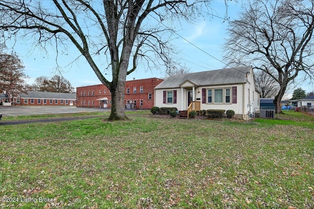 single story home featuring central AC unit and a front lawn