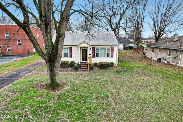 view of front of property featuring central AC unit and a front yard