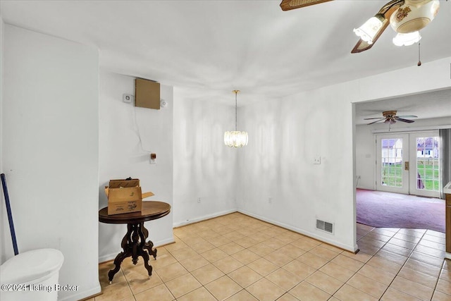 interior space with french doors, ceiling fan with notable chandelier, and light tile patterned floors