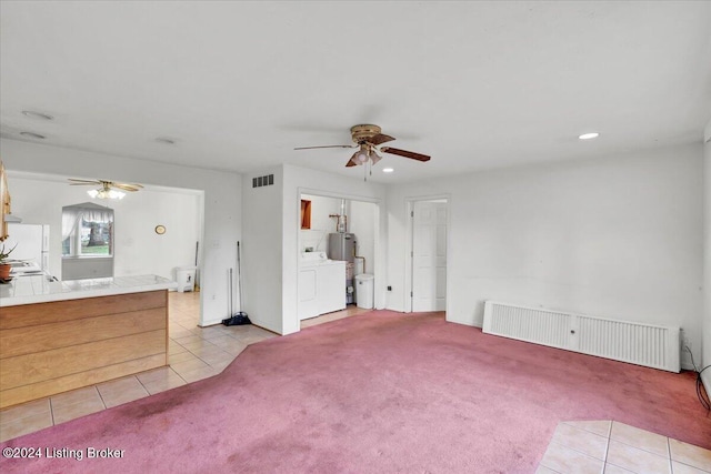 unfurnished living room with light carpet, radiator, water heater, and ceiling fan