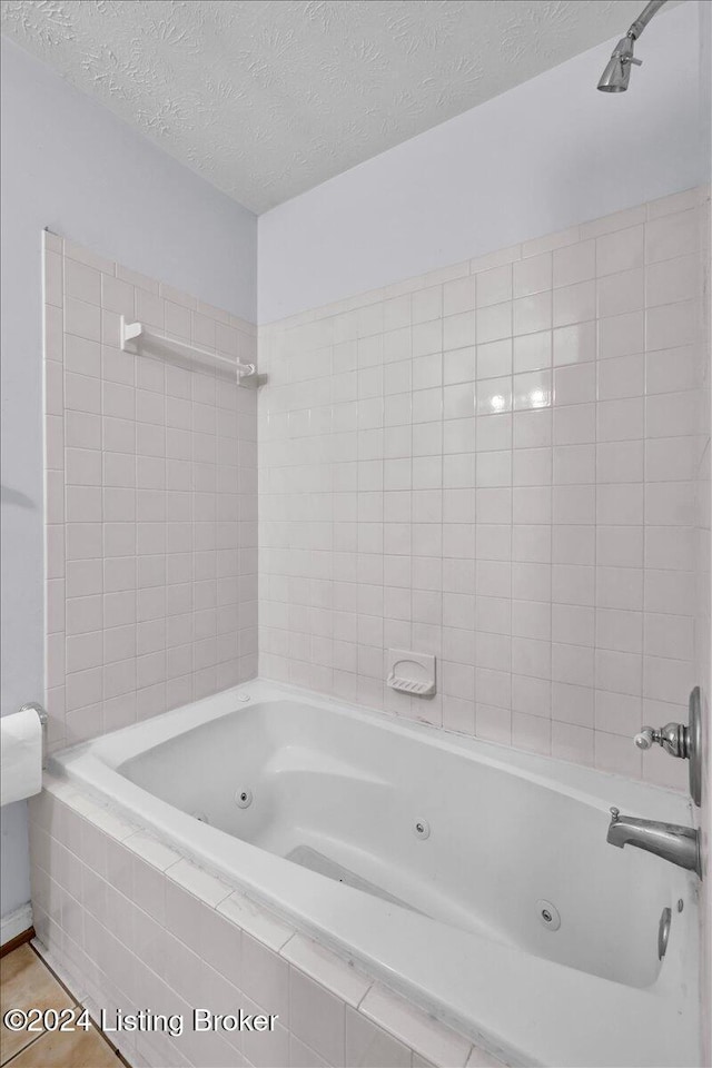 bathroom with tiled shower / bath and a textured ceiling