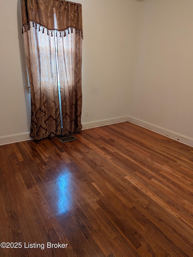 empty room with dark hardwood / wood-style floors