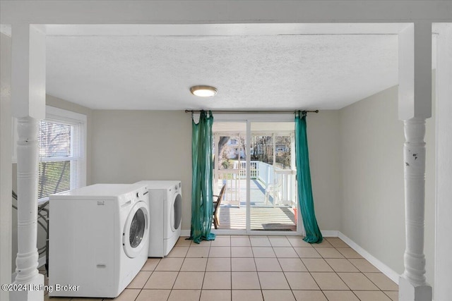 laundry room with independent washer and dryer, a textured ceiling, and light tile patterned floors