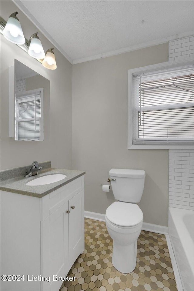 bathroom with vanity, a bath, a textured ceiling, and toilet