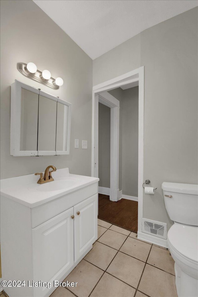 bathroom with tile patterned flooring, vanity, and toilet