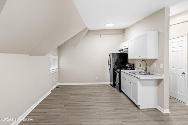 kitchen with black range with electric stovetop, white cabinetry, sink, and light hardwood / wood-style floors