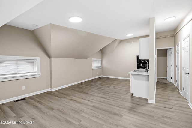 bonus room featuring light wood-type flooring and a healthy amount of sunlight