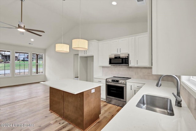 kitchen featuring white cabinetry, sink, pendant lighting, light hardwood / wood-style floors, and appliances with stainless steel finishes