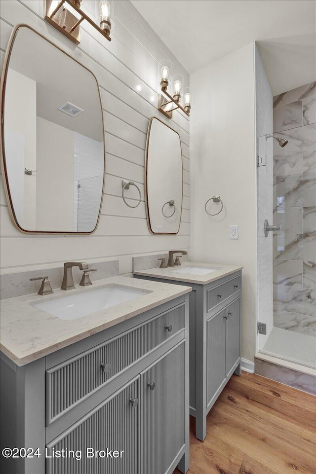 bathroom with vanity, wood-type flooring, and tiled shower