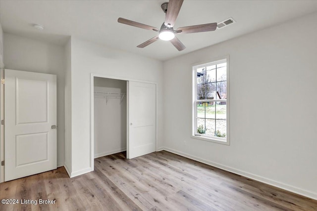 unfurnished bedroom with ceiling fan, a closet, and light wood-type flooring