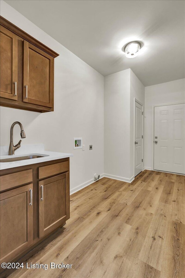 laundry area featuring cabinets, sink, hookup for a washing machine, hookup for an electric dryer, and light hardwood / wood-style floors