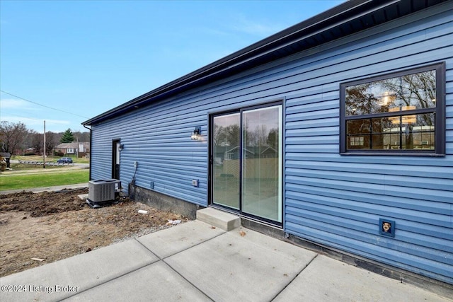 view of side of home with a patio area and cooling unit