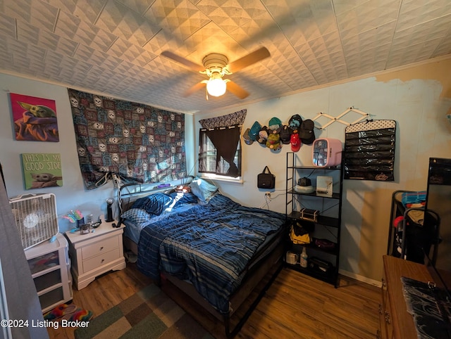 bedroom featuring ceiling fan, crown molding, and wood-type flooring