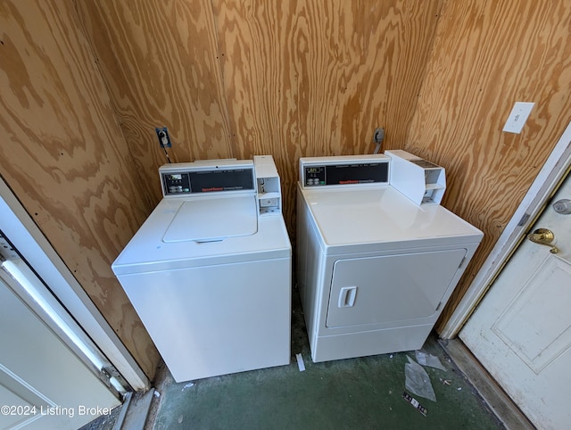 laundry area with washer and clothes dryer and wooden walls