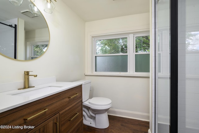 bathroom featuring toilet, vanity, an enclosed shower, and hardwood / wood-style flooring