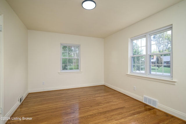 unfurnished room with plenty of natural light and hardwood / wood-style flooring