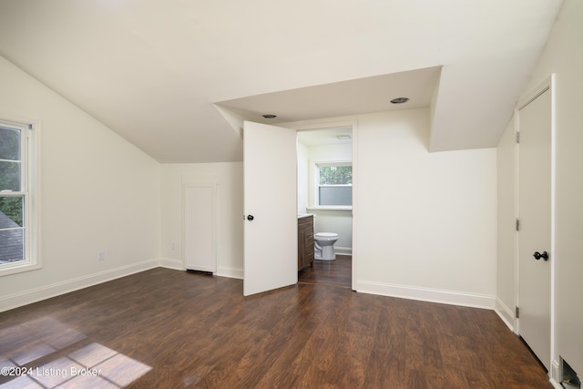 bonus room with dark hardwood / wood-style floors and vaulted ceiling