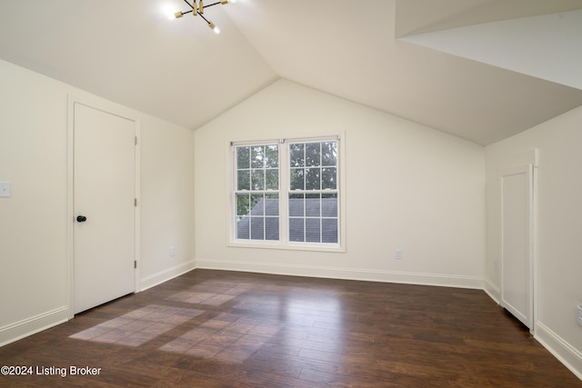 bonus room with dark wood-type flooring, lofted ceiling, and a notable chandelier