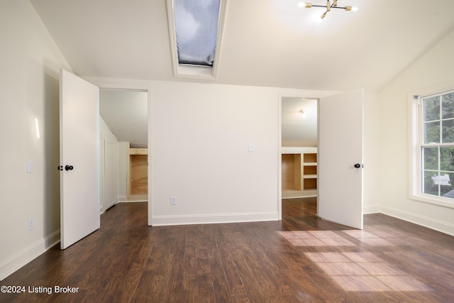 spare room with dark wood-type flooring, vaulted ceiling, and an inviting chandelier