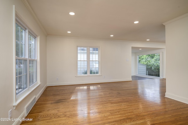 unfurnished room with light wood-type flooring and crown molding