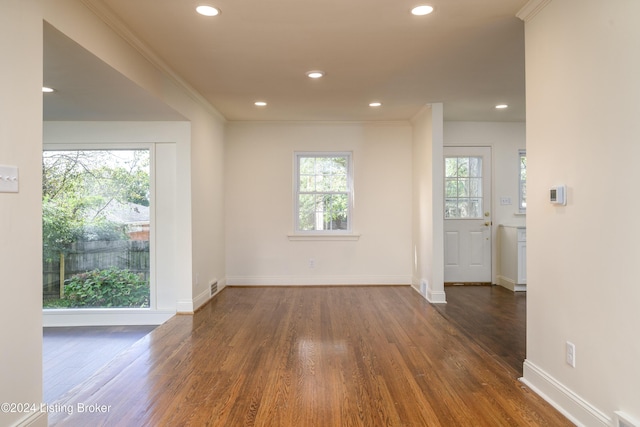 empty room with dark hardwood / wood-style flooring and ornamental molding