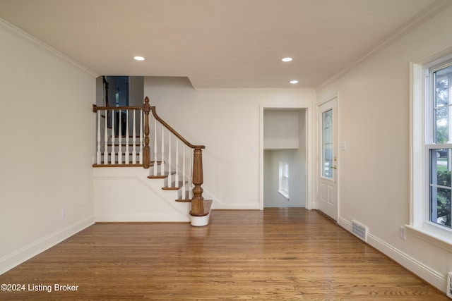 foyer entrance with light wood-type flooring and crown molding