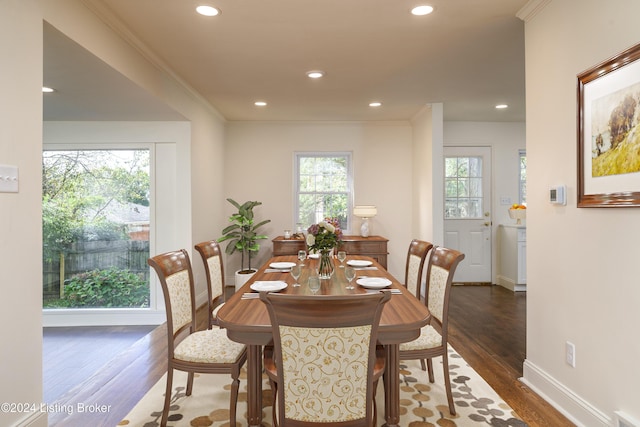 dining area featuring crown molding, dark hardwood / wood-style flooring, and a healthy amount of sunlight