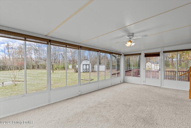 unfurnished sunroom with ceiling fan