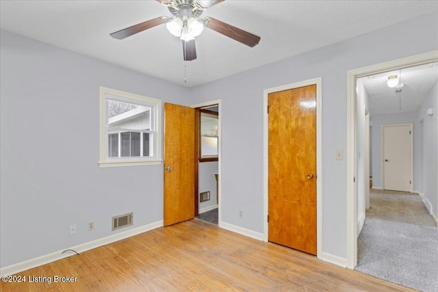 unfurnished bedroom with ceiling fan, light hardwood / wood-style floors, and a textured ceiling