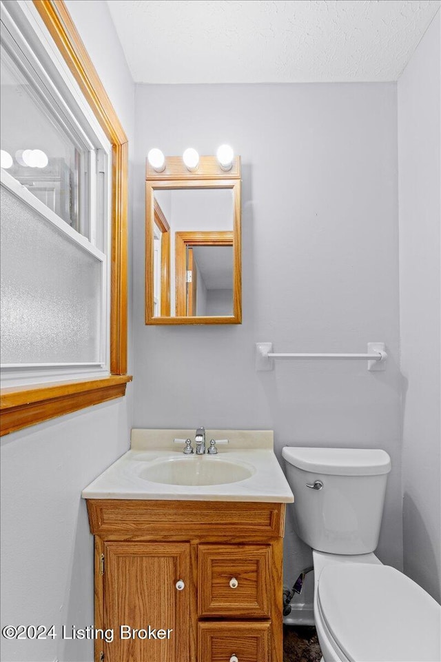 bathroom featuring vanity, toilet, and a textured ceiling