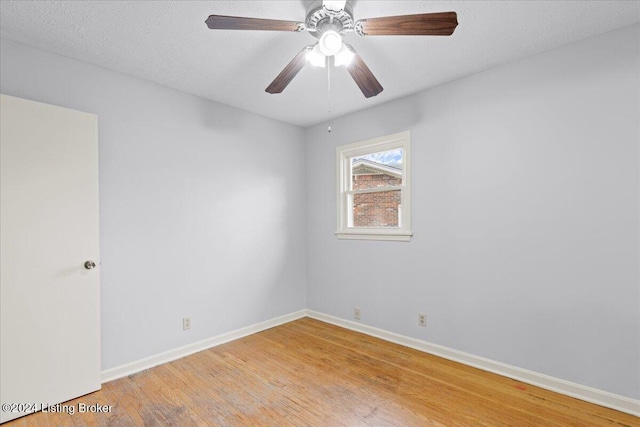 empty room with ceiling fan, light hardwood / wood-style flooring, and a textured ceiling