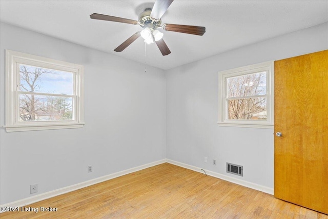 spare room with plenty of natural light, light hardwood / wood-style floors, and ceiling fan