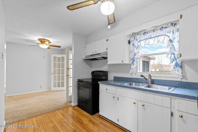 kitchen featuring sink, black electric range, a textured ceiling, white cabinets, and light wood-type flooring