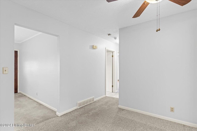 carpeted spare room featuring a textured ceiling and ceiling fan