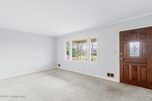 carpeted entrance foyer featuring a textured ceiling