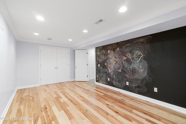 unfurnished room featuring hardwood / wood-style floors and crown molding