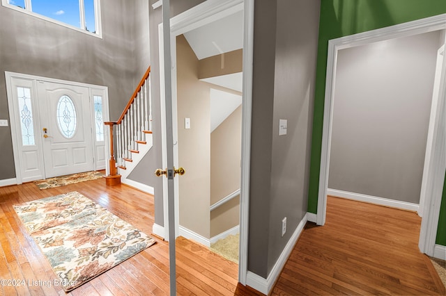 foyer entrance with lofted ceiling and hardwood / wood-style flooring