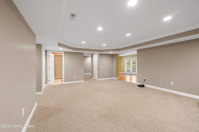 basement featuring light colored carpet and ornamental molding