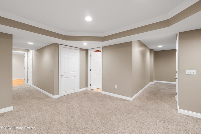 basement featuring light colored carpet and ornamental molding