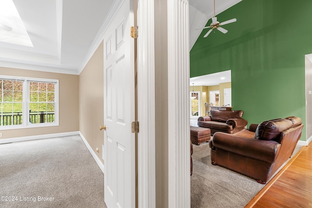 hall with ornamental molding, carpet floors, and lofted ceiling