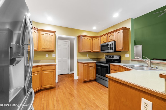 kitchen with light wood-type flooring, stainless steel appliances, and sink