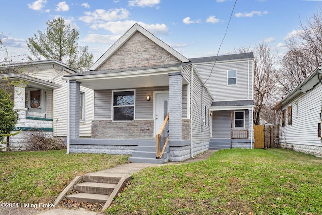 bungalow with a porch and a front lawn