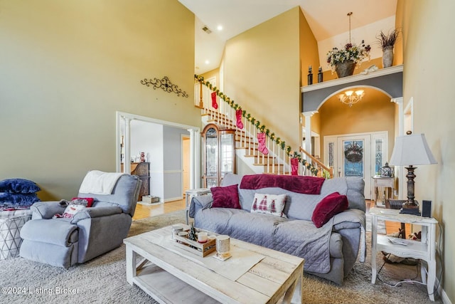 living room with carpet flooring, high vaulted ceiling, and a notable chandelier