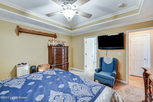 bedroom featuring a tray ceiling, ceiling fan, crown molding, and carpet