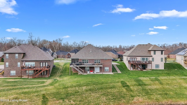 rear view of house with a yard and a wooden deck